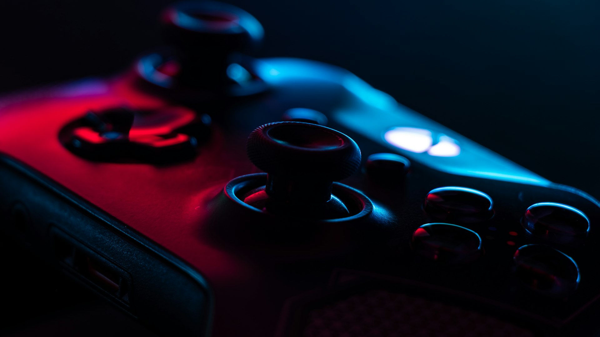 A dimly lit industrial gaming workspace with monitors glowing